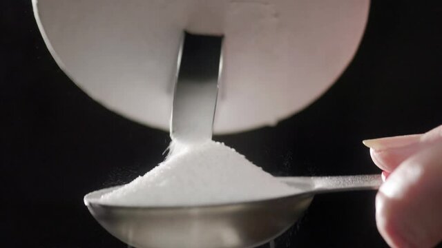 Excessive salt pouring out into a measuring spoon.