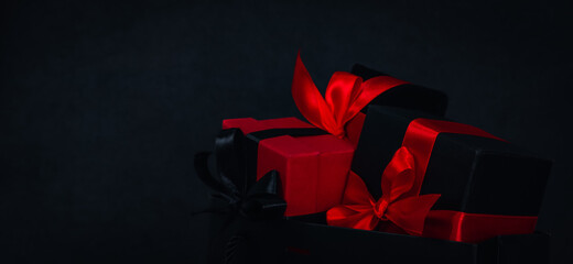 One paper bag with three gift boxes on the right against a black background.