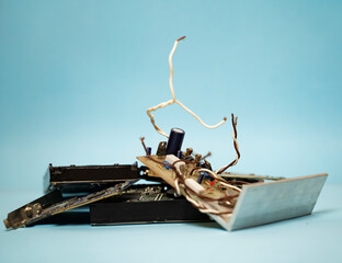 Old electric and computer components on blue background, e waste   