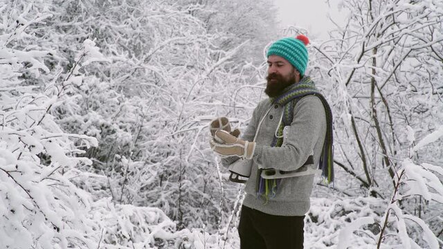 Bearded man in hat throwing a snowball. Expression of young man in snowball fight. Winter holiday.