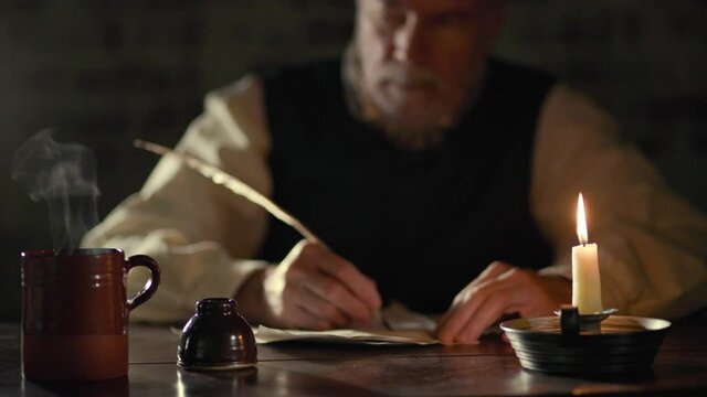Scene of a mature man in the 18th century lit by candlelight sitting at a desk with a hot beverage writing with a quill pen.