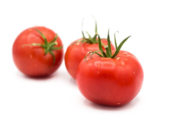 Ripe fresh organic tomatoes in drops of dew isolated on white background.
