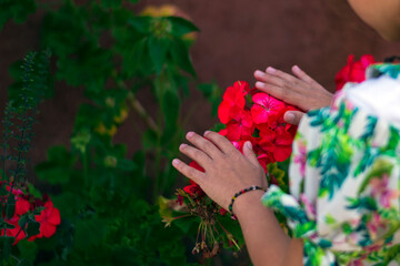 the hands of a little girl caressing some pink looking flowers