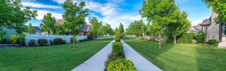 Straight concrete paths with shrubs in the middle of residential houses at Daybreak, Utah