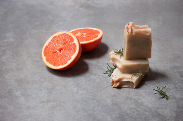 Fresh grapefruit and rosemary garnish on tropical soap bars.