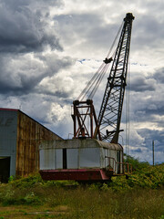 An Old mobile crawler crane with a stormy sky background.