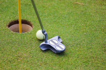 Golf clubs and ball lie on green grass in a rays of the everlasting sun. High quality photo