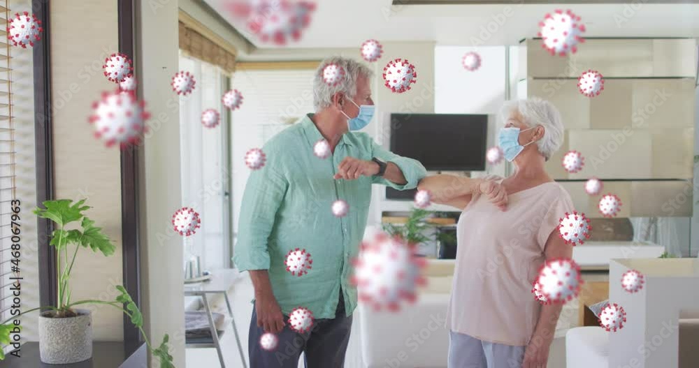 Wall mural Animation of covid cells over senior man and woman in face masks touching elbows