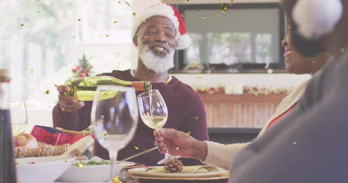 Multiple golden star icons floating against african american man pouring a dink for his wife