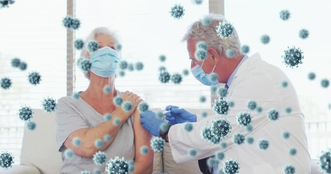 Animation of covid 19 cells over senior caucasian woman in face mask receiving vaccination