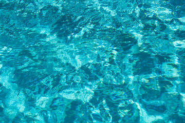 Background of blue water in swimming pool with sun reflection, ripple water wave in pool. Clear water background.
