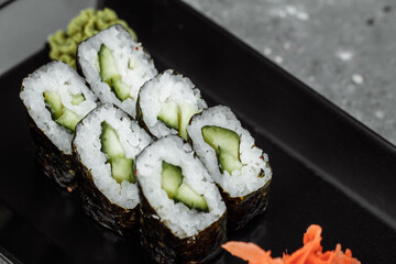 Delicious, juicy and mouth-watering maki with cucumber. Sushi on a gray background