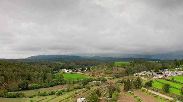 Aerial flying over green hills at Luciernagas countryside in Mexico at day
