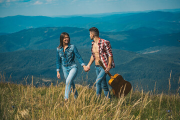 Fototapeta premium Young couple tourist. Camping lovers. Couple in love, lovers tourist walking. Young tourist couple travellers hiking in nature, walking and talking.