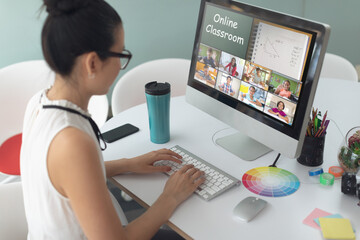 Caucasian girl using computer for video call, with diverse elementary school pupils on screen