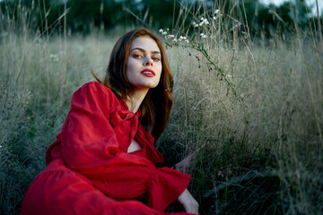 woman in red dress lies on the grass nature freedom rest