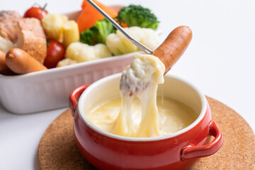 チーズホンデュとカラフルな蒸し野菜　
 パーティー料理が並ぶ白いテーブル