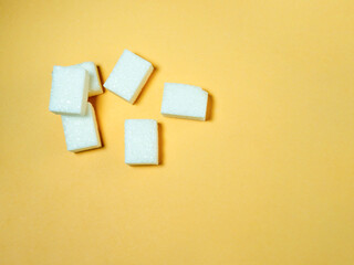 Sugar lumps on a yellow background.