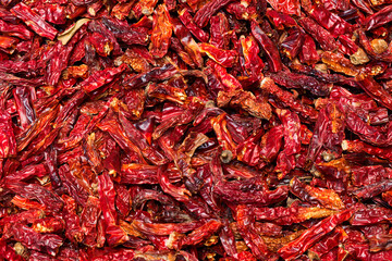 Close-up many fresh dried red chili peppers,  a popular Asian spice for cooking to make a spicy flavor, on top-view background