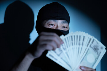 Image of a bad robber counting wads of cash that could be used for crime image up