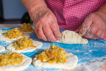 grandmother makes pies with cabbage from dough. High quality photo