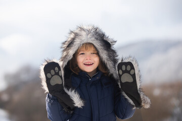 Fototapeta na wymiar Funny little child boy in winter outdoor in frost snowy day outdoor.