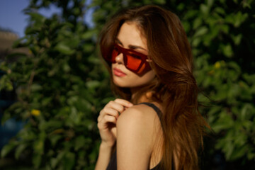 fashionable woman in sunglasses and green leaves summer exotic