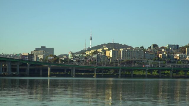 N Seoul Tower or Namsan Tower or YTN over blue cloudless sky from the waterfront of Han river in Autumn, Yongsan-gu South Korea
