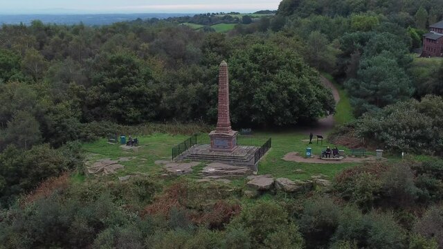 Aerial view sandstone obelisk war memorial Frodsham hill overlooking Cheshire Liverpool skyline orbit left