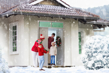 Family on Christmas day. Kids with gifts at door.