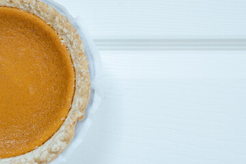 Horizontal close-up of pumpkin pie on white background