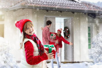 Family on Christmas day. Kids with gifts at door.