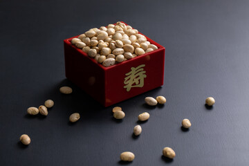 黒い背景と節分の福豆　
升から溢れる福豆