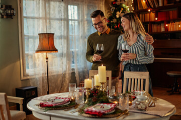 Fototapeta na wymiar Couple celebrating Christmas with red wine