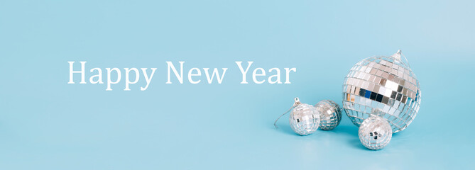 Disco ball on a pastel blue background, text Happy new year . Festive mockup minimalism party concept
