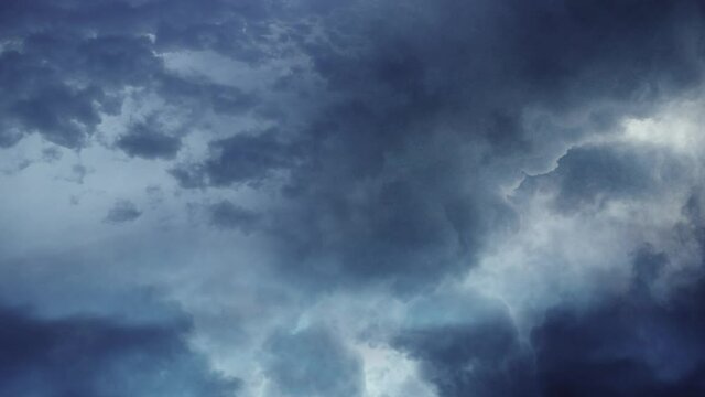 timelapse of blue sky and thunderstorm happening inside dark clouds.