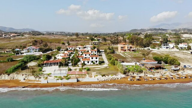 Pristine Blue Water And Brown Fine Sand Of Megas Lakkos Beach  With Matzivanata Settlement In Greece. aerial, static shot