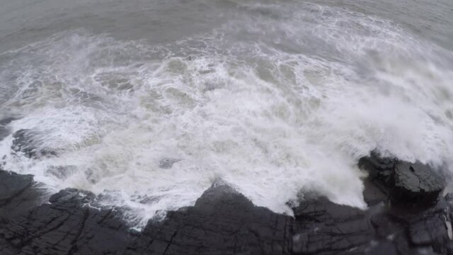 Devil's eye goa in monsoon. It is also known as devil's finger near Sinquerim Fort to Lower Aguada. Water waves crash into rocks and Sea foam creating amazing shapes and patterns