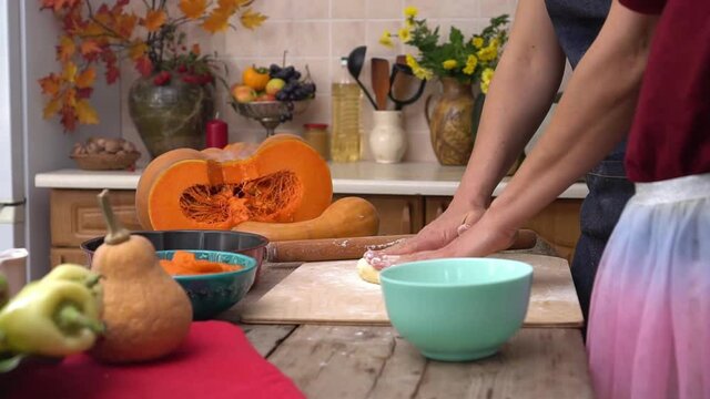 Mother and daughter cook pumpkin pie at home. Cooking together for a festive Thanksgiving dinner. A farmer's family celebrates the harvest festival