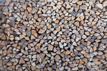 Natural wooden background - closeup of chopped firewood. Firewood stacked and prepared for winter Pile of wood logs