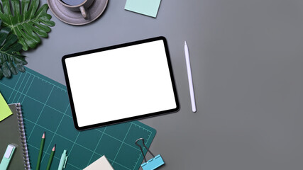 Above view designer workspace with digital tablet, coffee cup and stationery.