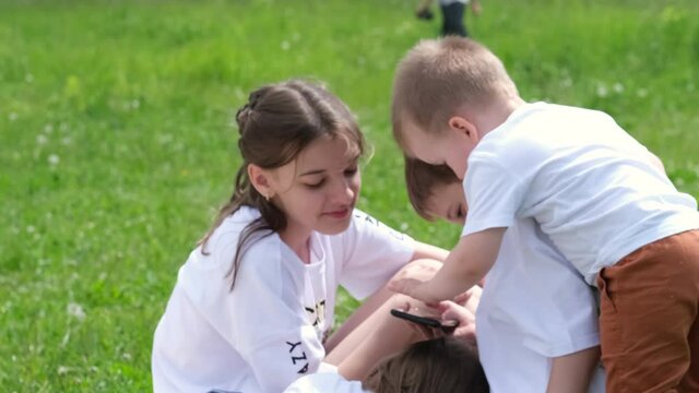 group of children of different ages are playing on the phone in the park. Selective focus