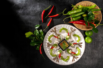 Raw Shrimp in fish sauce and many herbs. A delicious recipe from Asia and spices ingredients for cooking on dark black wooden table background, Thai food, Asian foods, Thailand restaurant menu