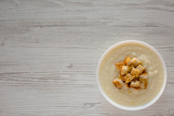 Homemade Cauliflower Soup with Croutons and Oil, top view. Flat lay, overhead, from above. Space for text.