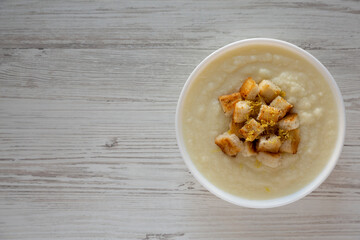 Homemade Cauliflower Soup with Croutons and Oil, top view. Flat lay, overhead, from above.