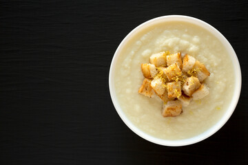 Homemade Cauliflower Soup with Croutons and Oil, top view. Flat lay, overhead, from above. Space for text.