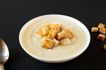 Homemade Cauliflower Soup with Croutons and Oil, side view.