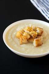 Homemade Cauliflower Soup with Croutons and Oil, low angle view. Close-up.
