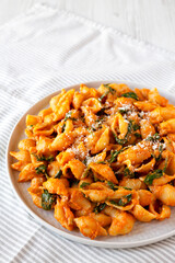 Homemade Pumpkin Pasta with Walnuts and Spinach, low angle view. Space for text.