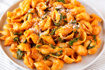 Homemade Pumpkin Pasta with Walnuts and Spinach, side view. Close-up.